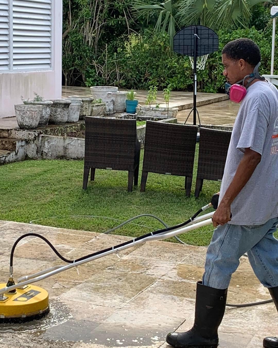 D.B. Clean242 technician using a professional surface cleaner to pressure wash a home patio