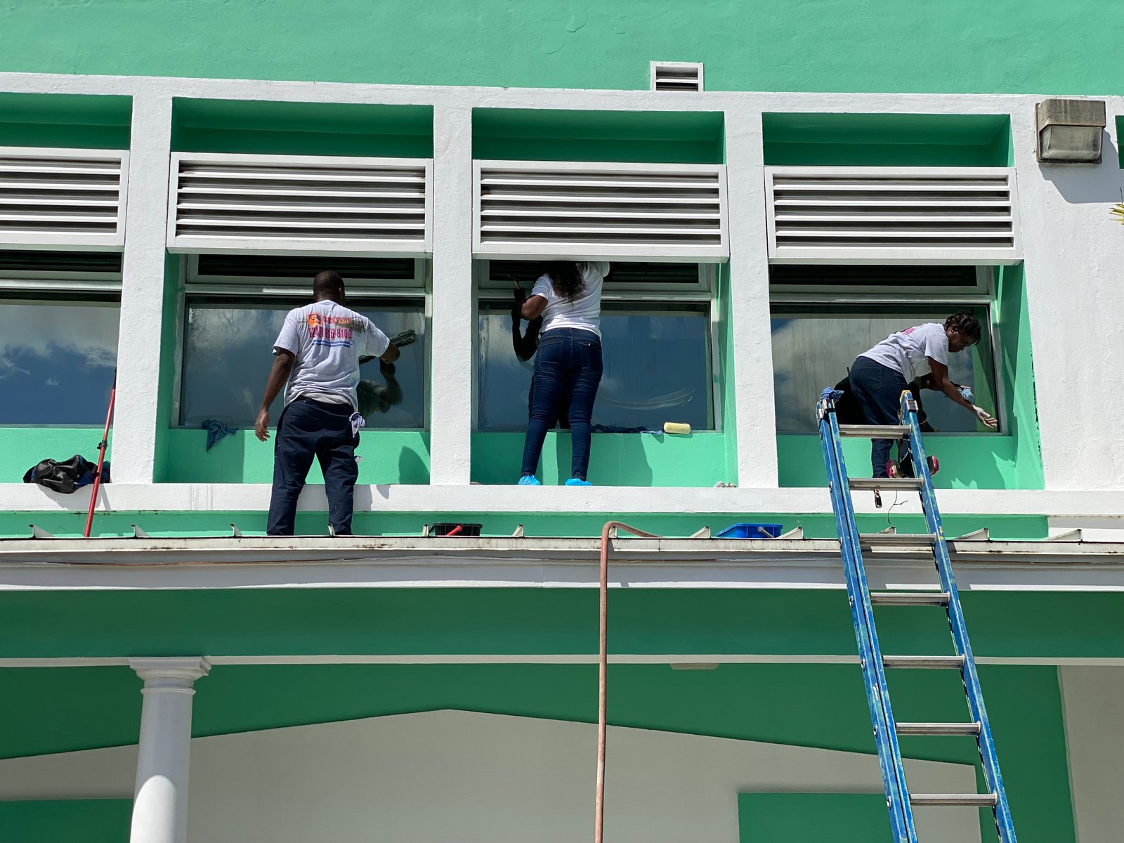 The D.B. Clean242 team cleaning windows on a commercial building in Nassau