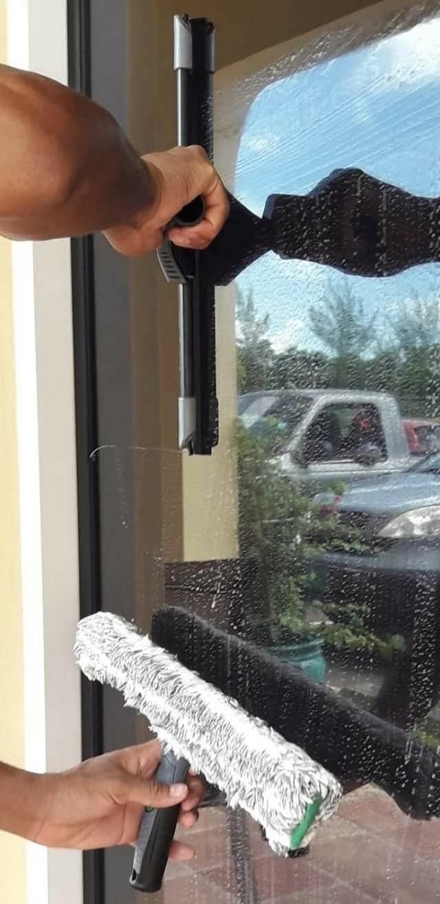 D.B. Clean242 technician squeegeeing a glass door with a professional applicator and squeegee